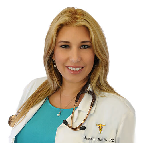 A headshot of Dr. Karla Medina, M.D. She has blonde hair and is wearing a white lab coat over a blue shirt and has a stethoscope draped around her neck.